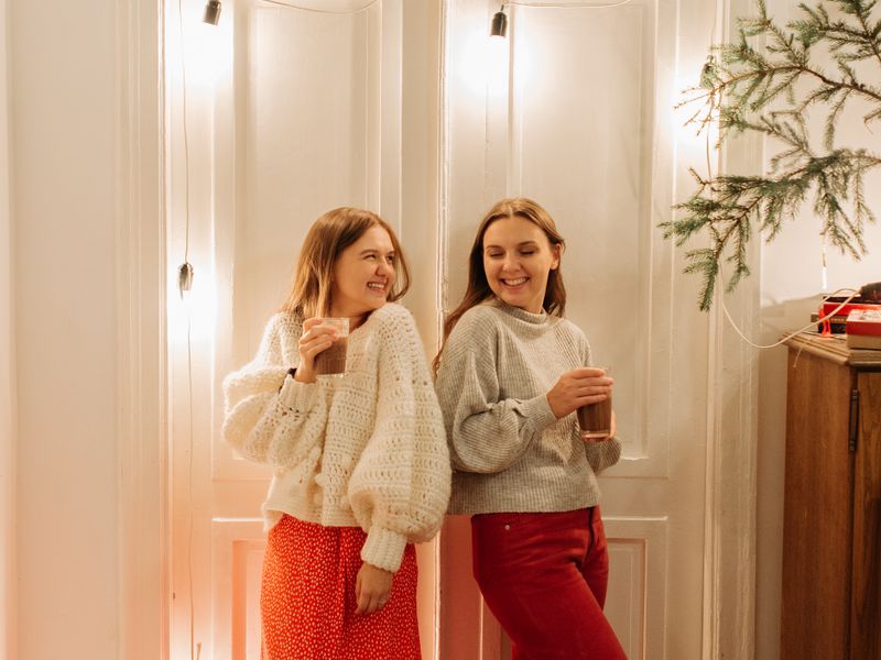 Two friends laughing at a festive holiday party